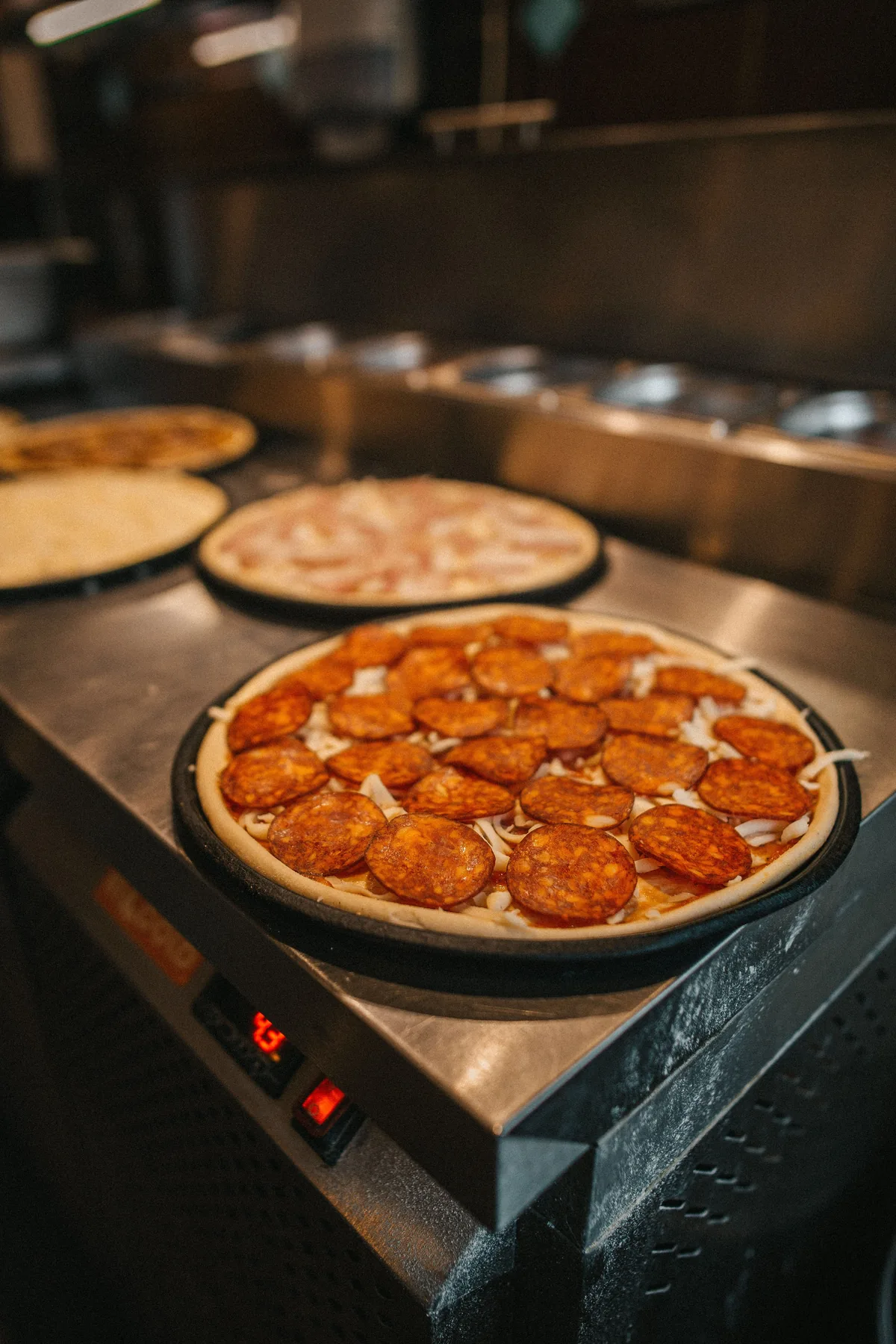 Unbaked pepperoni pizza resting on a kitchen counter