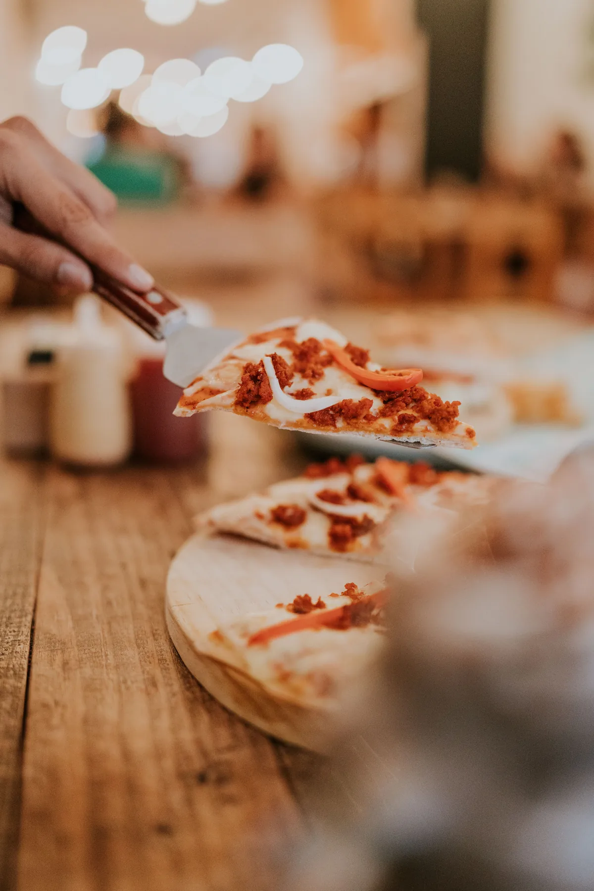 A slice being lifted from a pepperoni pizza
